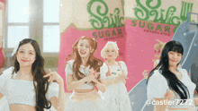 a group of girls are dancing in front of a sign that says snick sugar
