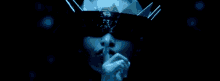 a person with a crown on their head covering their mouth with their hand