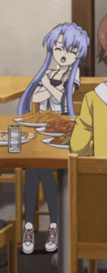 a girl sitting at a table with a plate of food