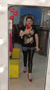 a woman is taking a selfie in front of a mirror in a store