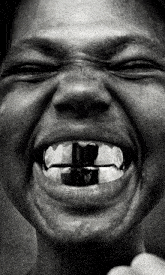 a black and white photo of a person 's mouth with a cross on it