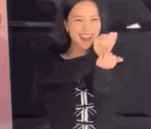 a woman is standing in front of a window with her hands outstretched .