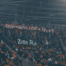 a crowd of people in a stadium holding a banner that says queremos copa teias