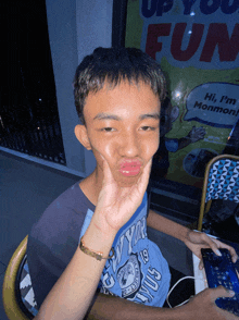 a boy making a face in front of a sign that says up your fun