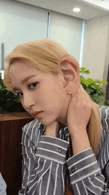 a woman in a striped shirt has a large ear on her head