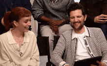 a man and a woman sitting next to each other smiling