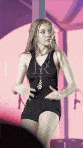 a woman in a black dress with the letter r on the bottom
