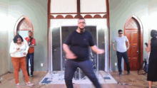 a man in a black shirt is dancing in front of a group of people
