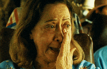 a woman covering her face with her hand and crying