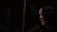 a man is holding a lightning bolt in his hand and screaming in the dark .