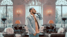 a man in a denim jacket is talking on a phone