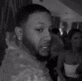 a black and white photo of a man with a beard hugging a woman .