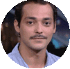a man with a mustache is wearing a blue shirt and looking at the camera .