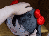 a person petting a stuffed animal with red bows
