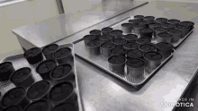 several trays of cupcakes are on a table with the words made in animotica on the bottom right