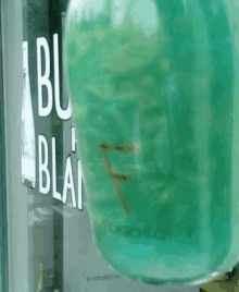 a bottle of abu blanc is sitting in front of a glass door