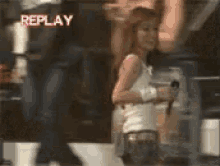 a woman standing in front of a replay sign
