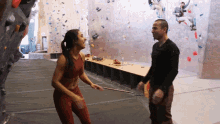 a man and a woman are standing next to each other in a gym