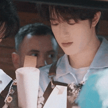 a man in an apron is looking at a white cup