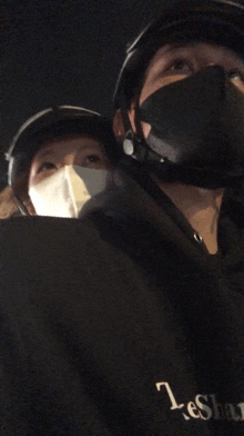 a man and a woman wearing face masks and a shirt that says leshan