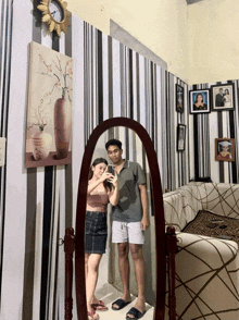 a man and a woman are taking a picture of themselves in a mirror