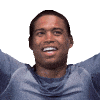 a man wearing a grey shirt is smiling with his arms in the air
