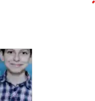 a young boy is wearing a plaid shirt and smiling .