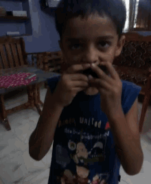 a young boy wearing a blue acorn united shirt