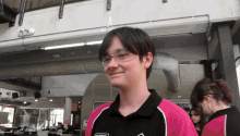a young man wearing safety glasses and a pink shirt that says ' a ' on the front
