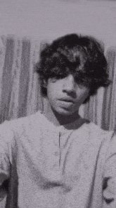 a young man is taking a selfie in front of a curtain .