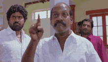 a man with a beard and mustache is pointing up with his finger