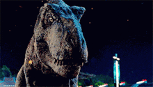 a t-rex dinosaur is looking at the camera with a dark background