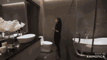a woman stands in a bathroom with the words made in animotica on the bottom right