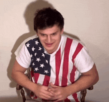 a man wearing an american flag t-shirt is making a funny face