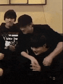 a group of young men are sitting on a couch .