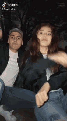 a man and a woman are sitting next to each other in a tik tok video