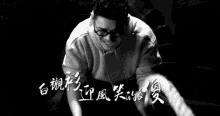 a black and white photo of a person holding a rope with chinese writing on it