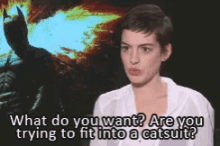 a woman in a white shirt is talking to a man in a batman costume