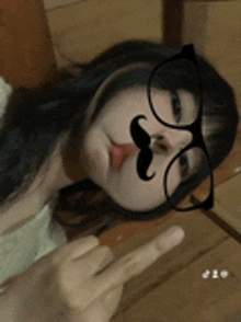 a woman wearing glasses and a fake mustache is giving the middle finger