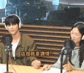 a man and a woman sitting in front of microphones with chinese writing on the bottom right