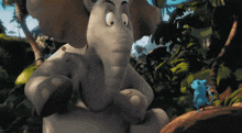 a cartoon elephant and a blue mouse are standing next to each other in the jungle