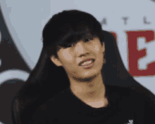 a young man is making a funny face in front of a sign that says e .