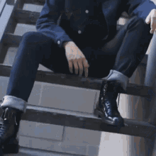 a man in a blue jacket is sitting on a set of stairs smiling .