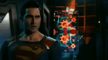 a man in a superman costume is standing in front of a blue light coming from his eyes .