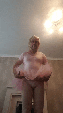 a man is wearing a pink tutu and wig