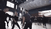a group of people are dancing in a room with a sign that says the can