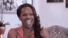 a woman is sitting on a couch and smiling .