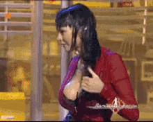 a woman in a red dress is adjusting her breasts