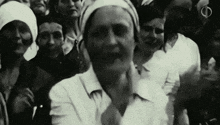 a black and white photo of a crowd of people standing in a line .
