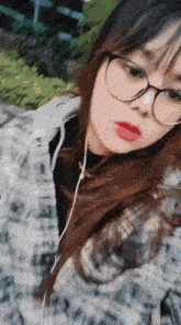 a girl wearing glasses and headphones takes a picture of herself